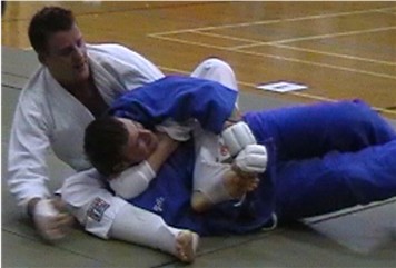 Simon defends the attempted strangle with a figure 4 ankle lock